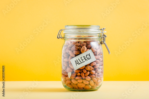 Glass jar full of peanuts with 'Allergy' sign in it. Food allergy and health concept