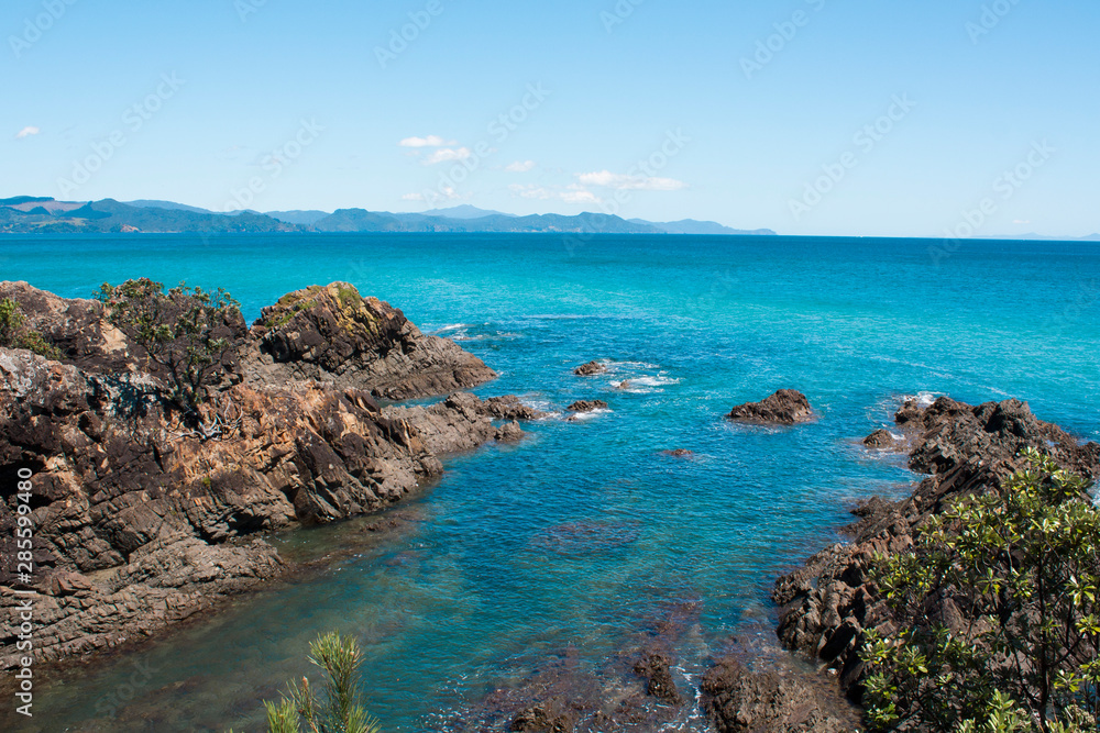 Kuaotunu beach from the north. Turquoise and blue water, rocky, great for snorkelling. Pohutukawa, NZs christmas tree. Summer scene, beautiful day, Coromandel is paradise. Postcard perfect sunny day. Kuaotunu beach from the north. Turquoise and blue water, rocky, great for snorkelling. Pohutukawa, NZs christmas tree. Summer scene, beautiful day, Coromandel is paradise. Postcard perfect sunny day.