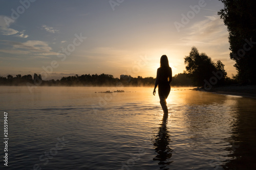 Frau badet im Sonnenaufgang