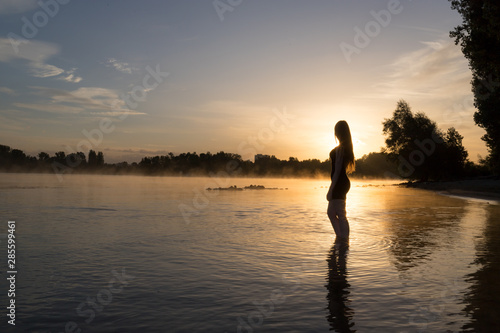 Frau badet im Sonnenaufgang
