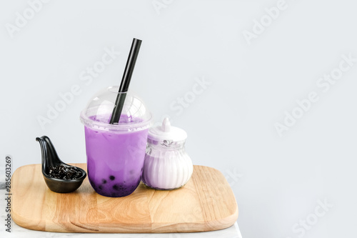 Purple sweet potato bubble milk tea with milk and bubble topping for tea or other beverage on the marble table with copy-space for textures and wall Natural light background