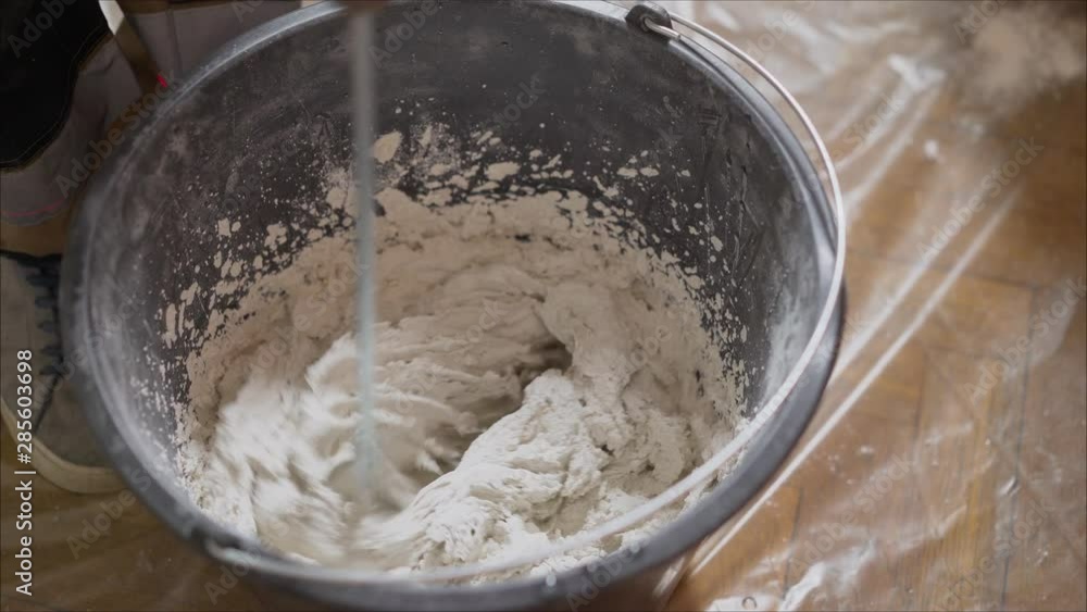 Stir the building mix in a bucket. Stirs the solution in a bucket Stir the building mix in a bucket. Stirs the solution in a bucket