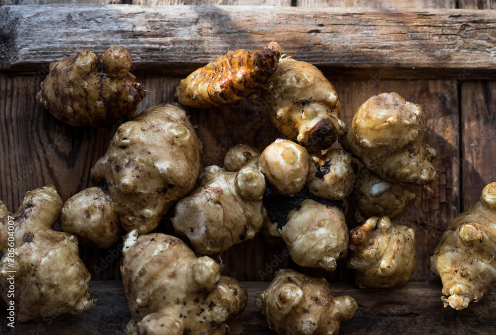 Whole ans sliced Jerusalem artichokes on a cutting board Whole ans sliced Jerusalem artichokes on a cutting board