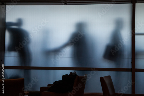 Canvas Print smokers in an airport behind a frosted glass