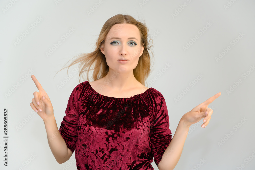 Studio waist-length photo portrait of a pretty beautiful young happy blonde woman on a white background in a red blouse. Smiling, talking, showing emotions. Studio waist-length photo portrait of a pretty beautiful young happy blonde woman on a white background in a red blouse. Smiling, talking, showing emotions.