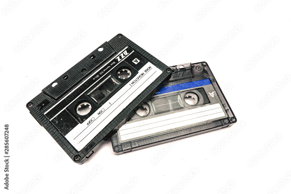 Fototapeta premium Two black cassettes on white background. Vintage audio tapes. Old-fashioned musical objects.