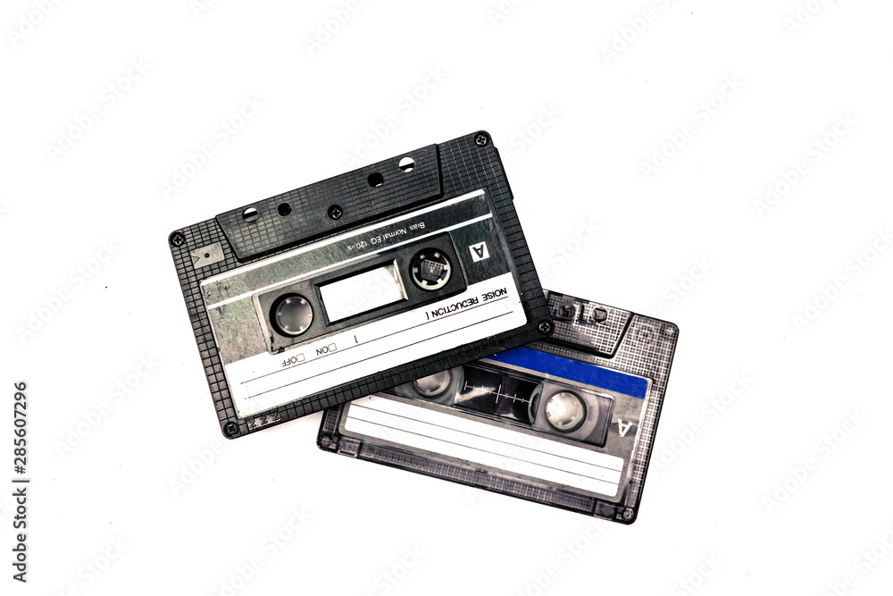 Fototapeta premium Two black cassettes on white background. Vintage audio tapes. Old-fashioned musical objects.