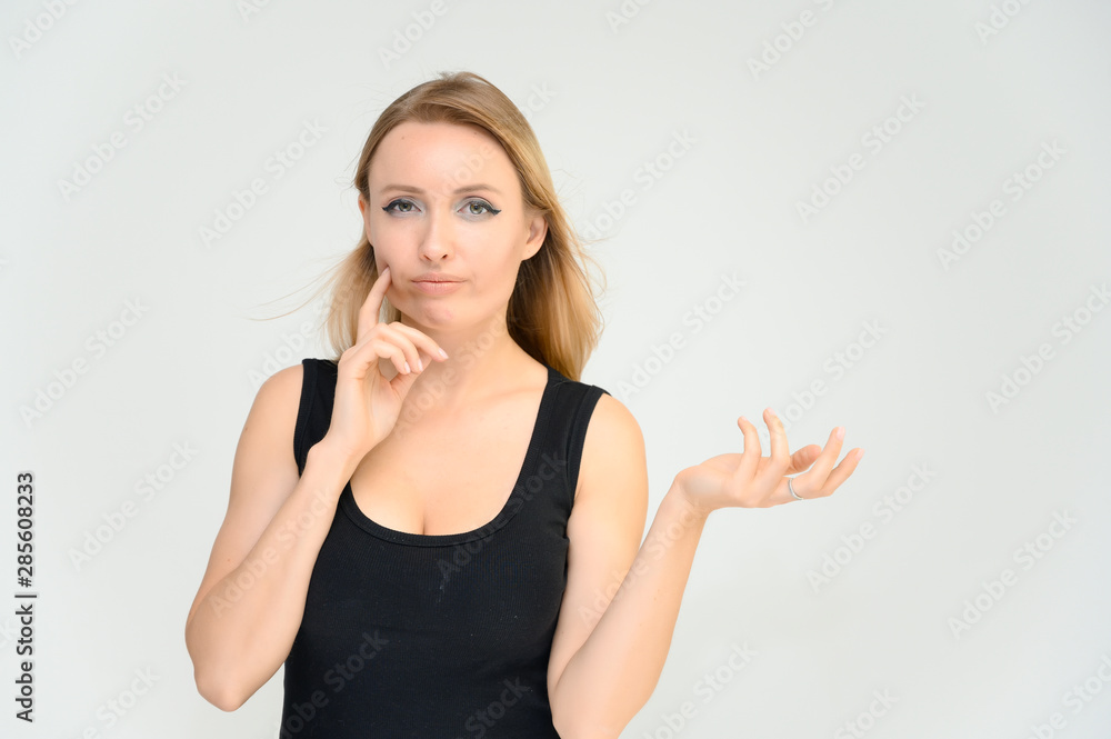 Studio waist-length photo portrait of a pretty beautiful young happy blonde woman on a white background in a black t-shirt. Smiling, talking, showing emotions. Studio waist-length photo portrait of a pretty beautiful young happy blonde woman on a white background in a black t-shirt. Smiling, talking, showing emotions.