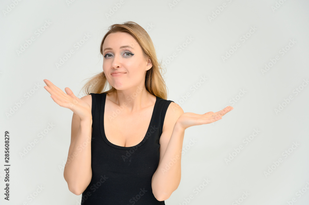 Studio waist-length photo portrait of a pretty beautiful young happy blonde woman on a white background in a black t-shirt. Smiling, talking, showing emotions. Studio waist-length photo portrait of a pretty beautiful young happy blonde woman on a white background in a black t-shirt. Smiling, talking, showing emotions.