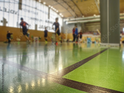 Floor surface marked with black lines. Players out of focus
