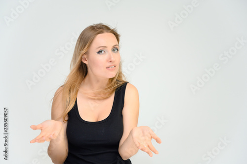 Wallpaper Mural Studio waist-length photo portrait of a pretty beautiful young happy blonde woman on a white background in a black t-shirt. Smiling, talking, showing emotions. Torontodigital.ca