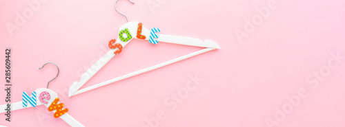 White hangers with sale text on pink background