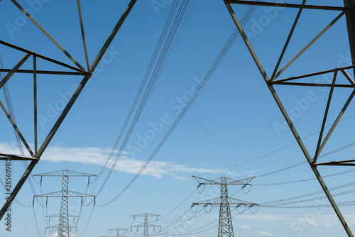 Electricity mast and transmission towers on the background on a blue sky