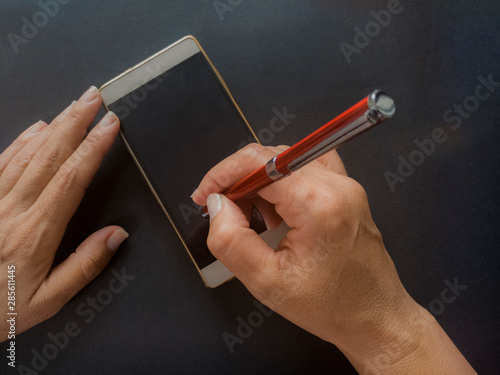 Manos de mujer firmando en un dispositivo móvil. Concepto Firma Electrónica