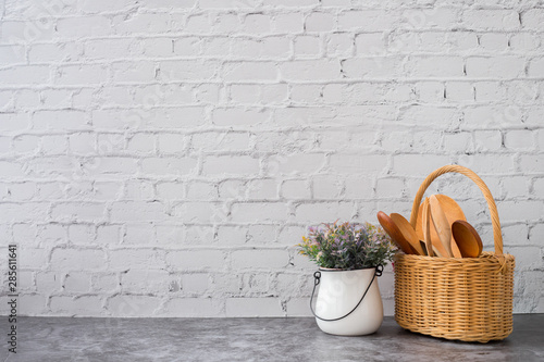 wooden kitchenware and flower pot on white brick wall texture background.
