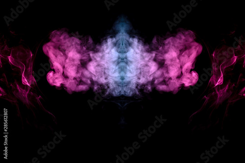 Smoke of different blue, red and pink colors in form of horror in the shape of the head, face and eye with wings on a black isolated background. Soul and ghost in mystical symbol. Print for clothes.