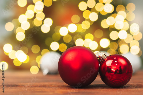 Christmas balls on a wooden table against blurred shiny bokeh background