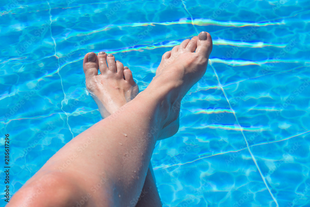 Feet of a woman on the swimming pool