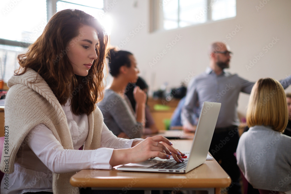 Beautiful girl taking notes in multinational group of students in an auditorium Beautiful girl taking notes in multinational group of students in an auditorium