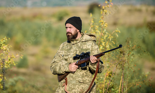 Man brutal gamekeeper nature background. Hunter hold rifle. Bearded hunter spend leisure hunting. Focus and concentration of experienced hunter. Hunting and trapping seasons. Hunting masculine hobby
