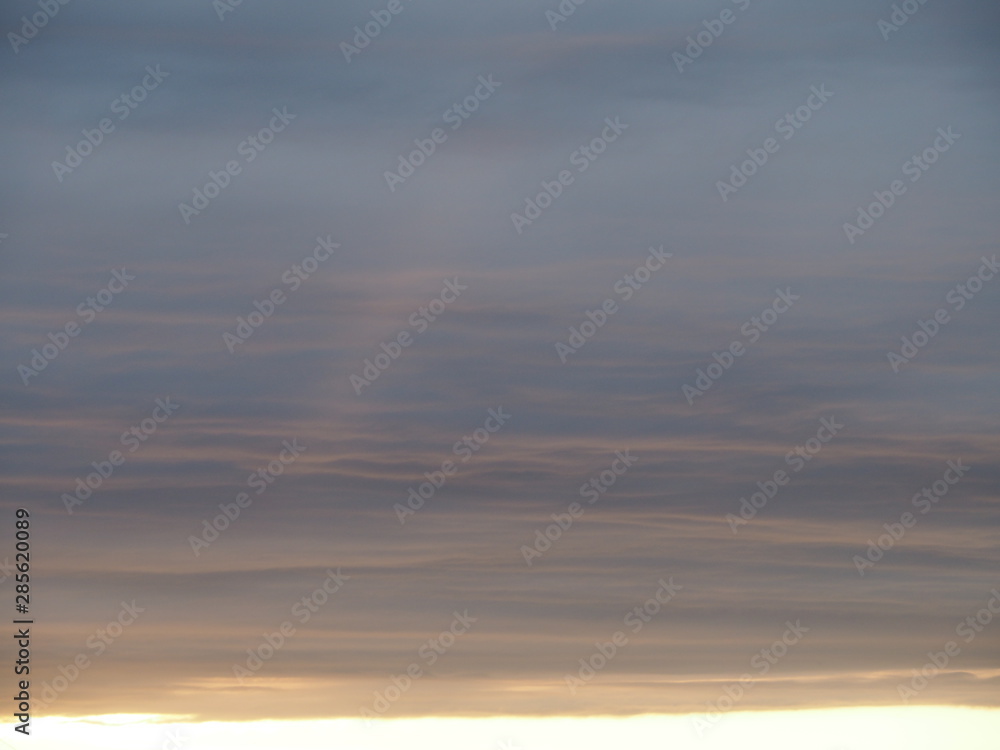 Gentle sky with horizontal colored stripes and a ray of sun at sunset. Clean and calm template for decoration.