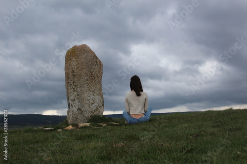 paysage en lozère avec une fille assise près d'un dolmen  photo