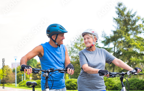 Fit senior couple with bicycles looking at each other © moodboard