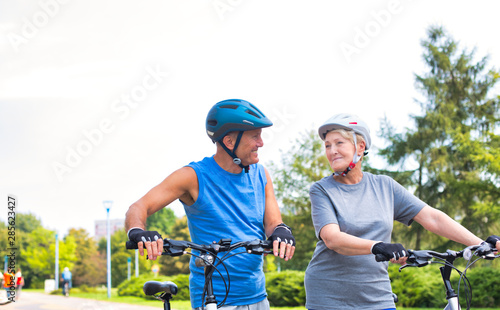 Fit senior couple with bicycles looking at each other