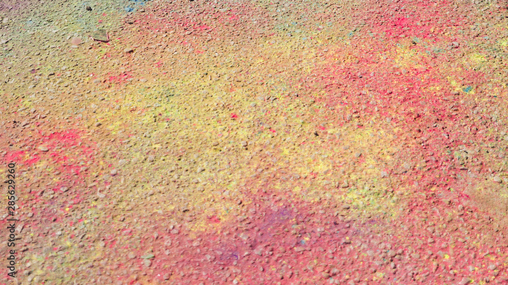 Pink and yellow holi color on ground