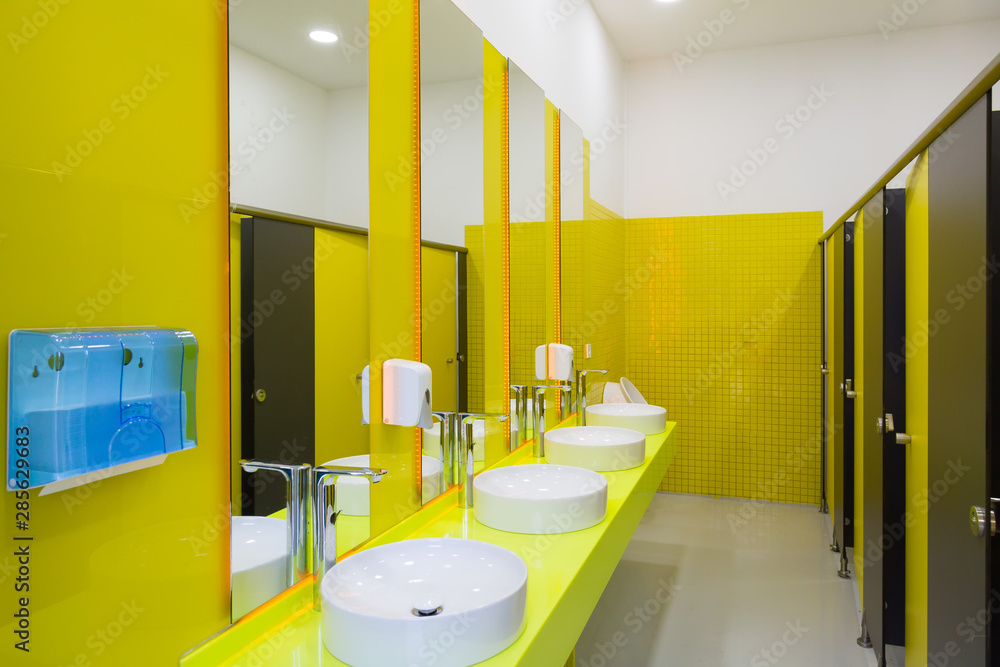 Public toilet with yellow walls. Toilet with cubicles with bright yellow  walls. Modern toilet design. Stock Photo | Adobe Stock
