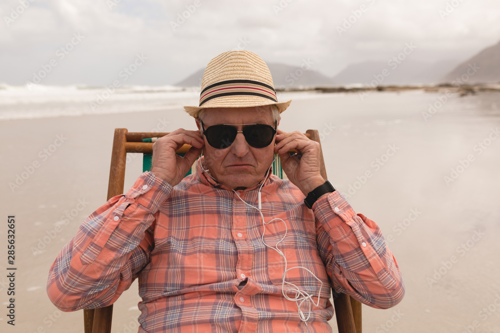 Man wearing earphones while relaxing in a sun lounger 