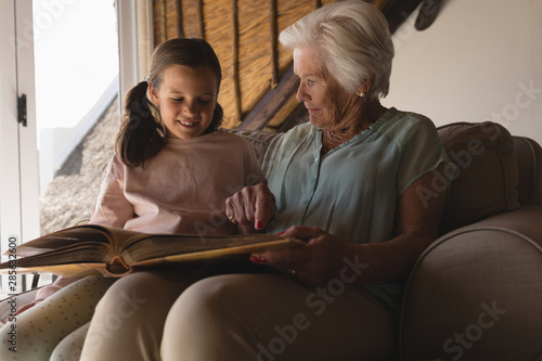 Grandmother and granddaughter looking at photo album