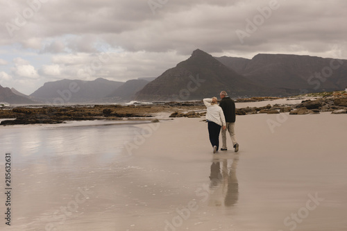 Senior couple walking together at the beach 