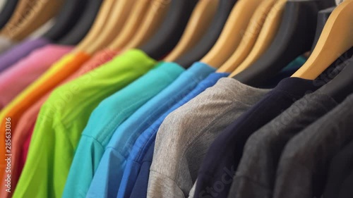 Close up of Colorful t-shirts on hangers, apparel background