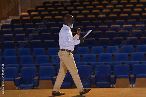  Businessman practicing and learning script while walking in the auditorium