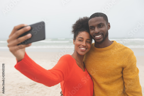 Romantic couple taking selfie at beach on a sunny day