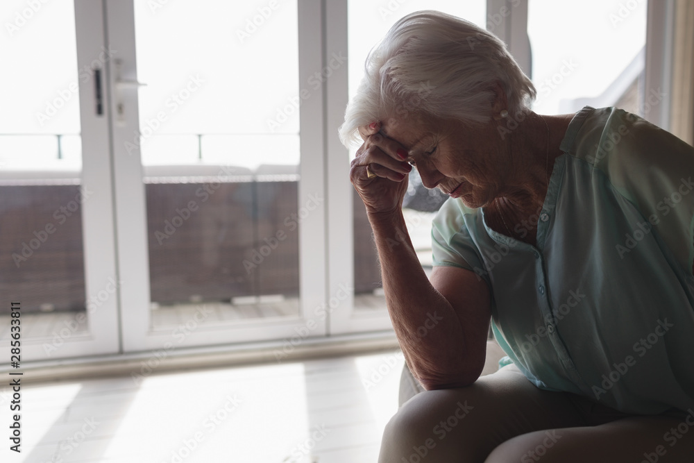 Worried senior woman sitting in living room Worried senior woman sitting in living room