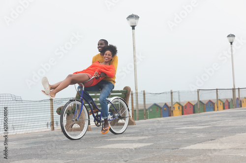 Couple enjoying at bicycle while riding at pavement 