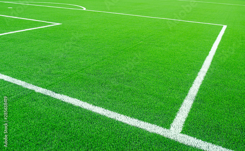 Artificial green grass with white stripe on sports fields for soccer and football.