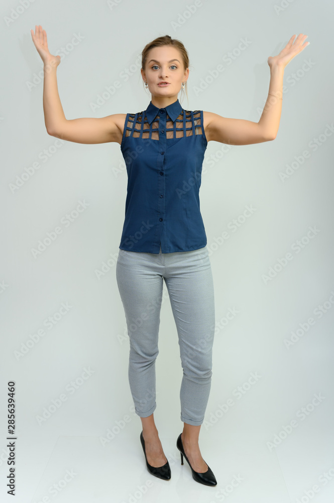 Full length studio portrait of a pretty young woman girl in a business suit on a white background. He stands right in front of the camera, explains, shows his hands with emotions. Full length studio portrait of a pretty young woman girl in a business suit on a white background. He stands right in front of the camera, explains, shows his hands with emotions.