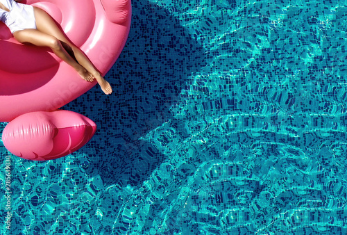 Obraz na płótnie Summer vibes tourist vacation mood concept. Top view. Beautiful woman legs relaxing on pink flamingo float w salonie