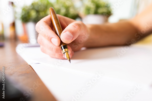 Signing contract. The man signs the document with a fountain pen. Businessman writes with pen, signing