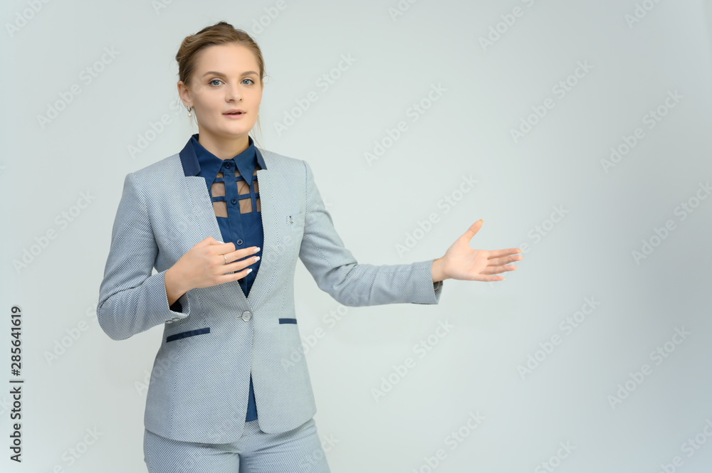 Studio photo a waist-high portrait of a pretty young woman girl in a business suit on a white background. He stands right in front of the camera, explains, with emotion. Studio photo a waist-high portrait of a pretty young woman girl in a business suit on a white background. He stands right in front of the camera, explains, with emotion.