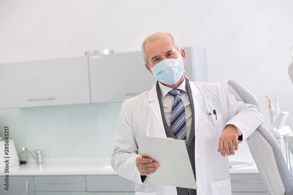 Portrait of senior dentist wearing mask at dental clinic Portrait of senior dentist wearing mask at dental clinic