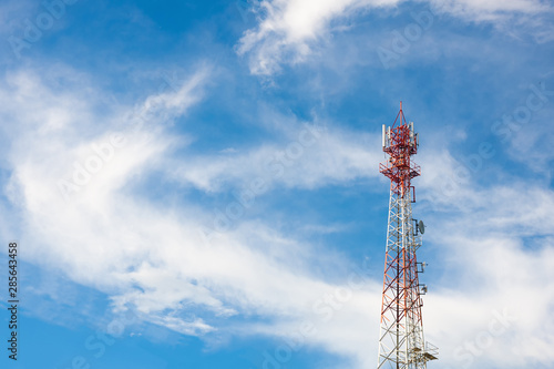 white-red color antenna repeater tower on blue sky.with clouds