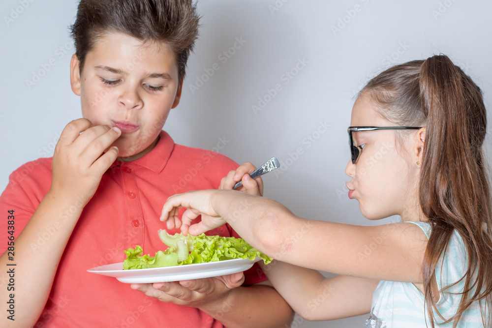 Children eat vegetable salad Children eat vegetable salad