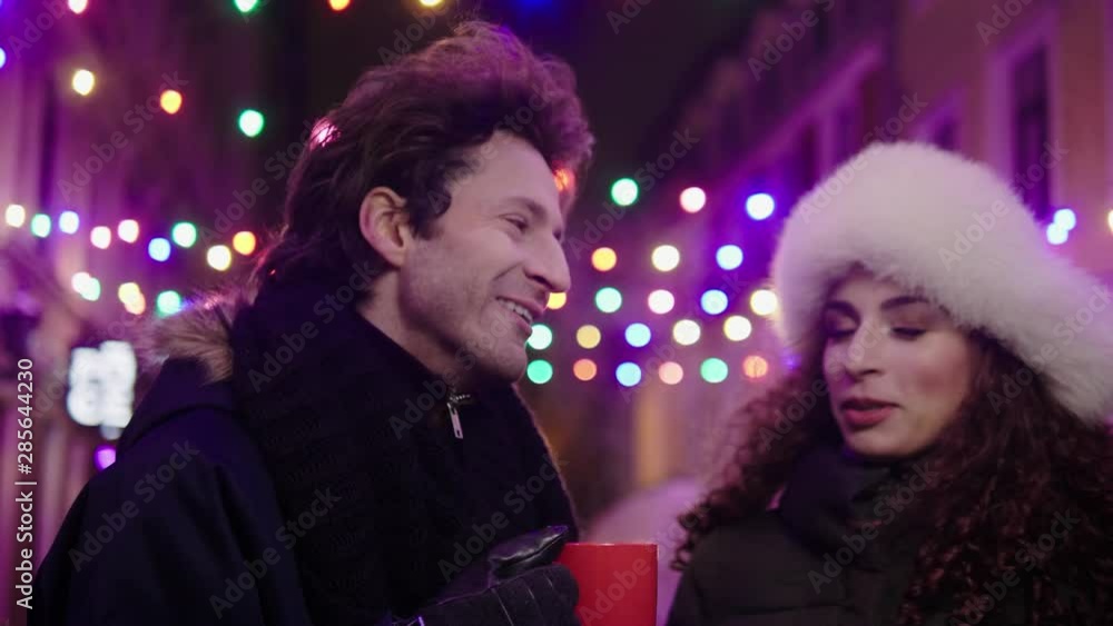 Couple with hot drinks outdoor on a cold winter evening Couple with hot drinks outdoor on a cold winter evening