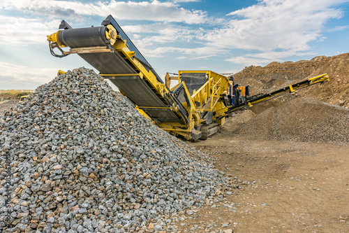 Stone crusher machine in a quarry or open-pit mine, to transform into gravel photo