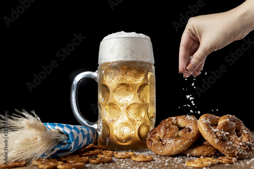 Fotografia Hand sprinkling salt on bavarian snacks
