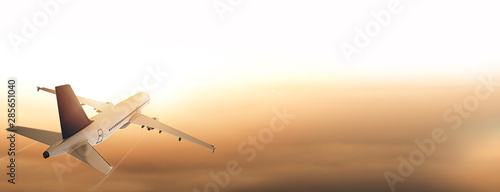 Flugzeug über den Wolken fliegt Richtung Sonnenaufgang